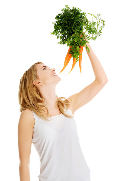 Young woman with the carrots - Фото, зображення