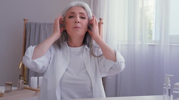 Videó hívás tutorial szépség blog vlog kaukázusi öreg befolyásoló nő idősebb nő vlogger blogger beszél a kamera konferencián mutatja fejmasszázs ősz haj növekedés masszírozó frizura - Felvétel, videó