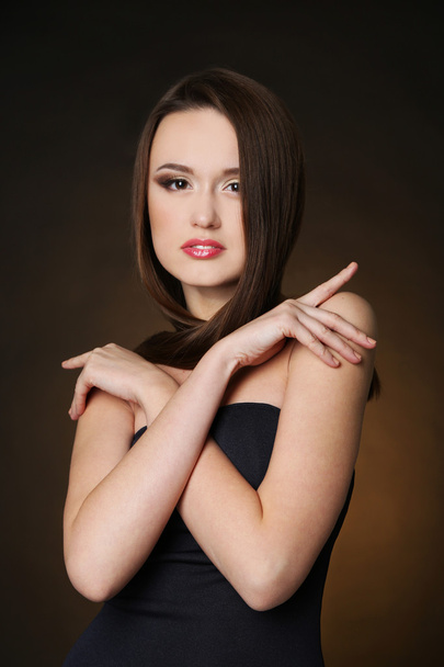 Beautiful young woman with long hair on dark brown background - Zdjęcie, obraz