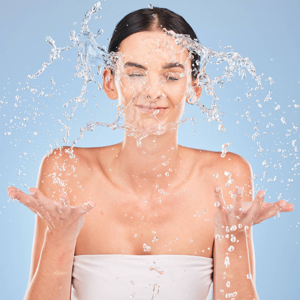 Water splash, face and studio woman with skincare wellness, beauty and cosmetics cleaning for healthy glow or shine in dermatology. Young model, water drops and morning facial wash in bathroom mockup. - Photo, Image