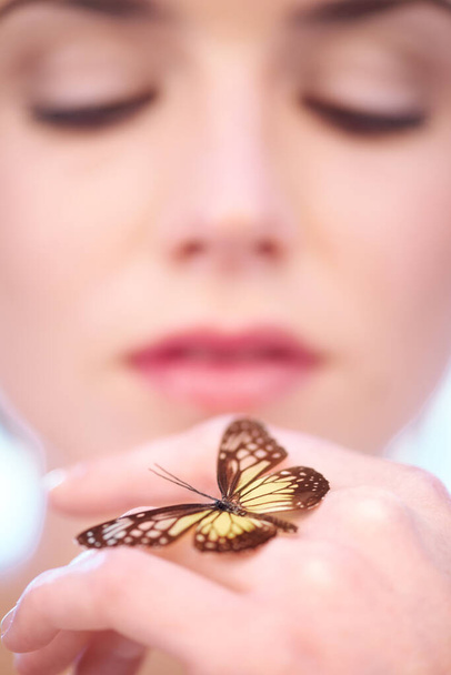 Eco-friendly skincare. A woman holding a butterfly on her hand - Фото, зображення