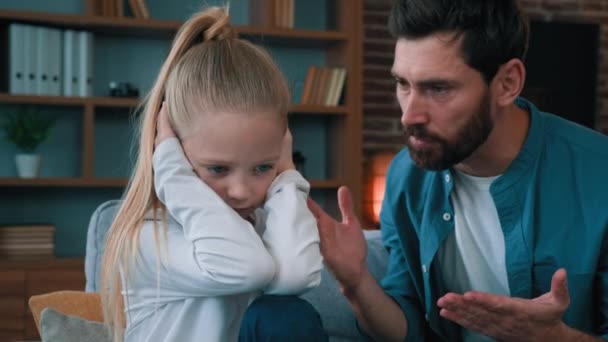 Sad offended little child daughter feel stress cover ears ignoring scream caucasian angry annoyed man dad shouting on girl for bad behavior and disobedience scolding kid problem of parenting in family - Footage, Video