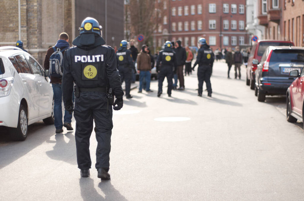 Sokakları sakin tutmak. İsyan kıyafetli bir polisin dikiz görüntüsü - Fotoğraf, Görsel