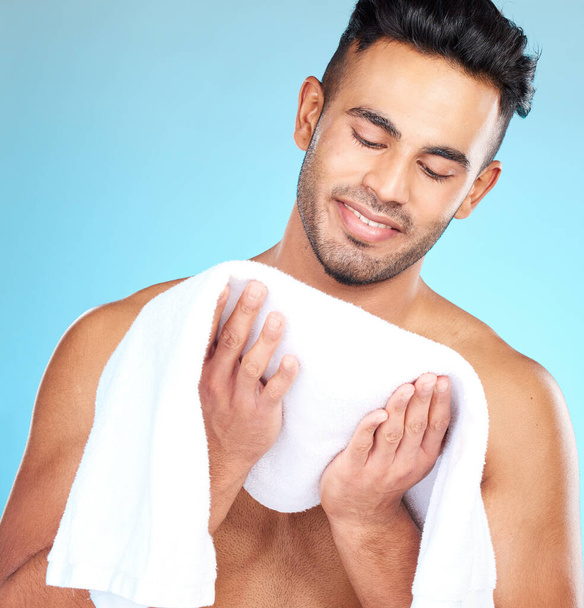 Cleaning, towel and face of man clean after wellness wash, facial cleaning routine and skincare mockup. Happiness, smile and person after bath or shower for body self car on blue studio background. - Fotoğraf, Görsel