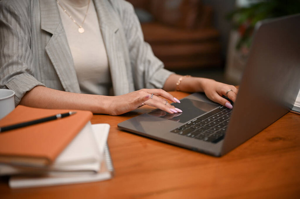 Millennial Asian businesswoman or female manager planning her project, using laptop computer, hand typing on keyboard. cropped and close-up image - Foto, imagen