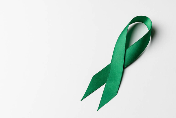 Close up of green ribbon on white background with copy space. Medicine, healthcare and science concept. - 写真・画像