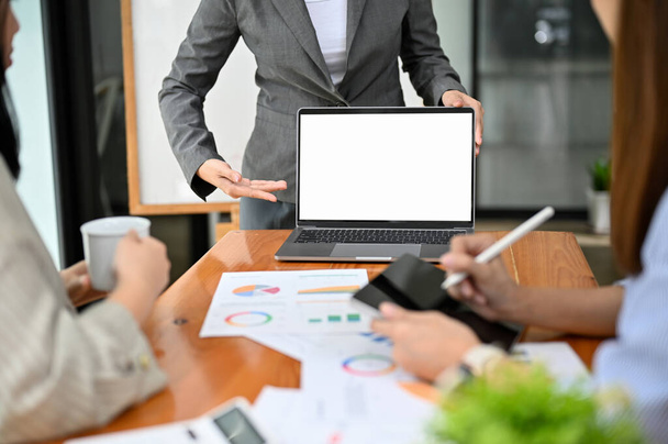Професійна бізнес-леді або жіночий менеджер представляє її деталі проекту через ноутбук перед своєю командою на зустрічі. ноутбук білий макет екрану. обрізане зображення
 - Фото, зображення