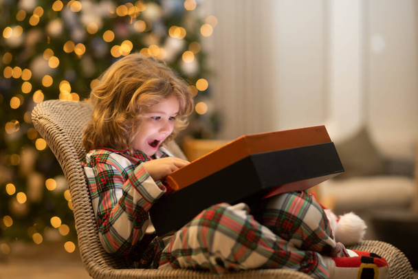 Surprise kid opening Christmas present gift box. Child preparing for the Christmas and New Year holidays - Valokuva, kuva