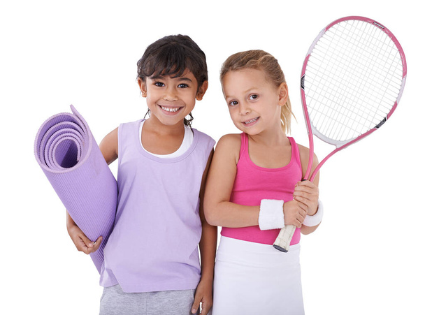 Quand nous grandirons, nous serons des pros. Portrait de deux petites filles en tenue de sport debout l'une à côté de l'autre isolées sur blanc - Photo, image