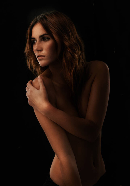 Beautiful and bare. A beautiful young woman standing against a black background - Foto, imagen