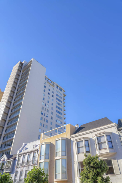 San Francisco 'da orta katlı apartman dairesinin yakınındaki alçak katlı daireler. Ön tarafında farklı dış görünüşlü alçak binalar ve daha yüksek pencereli binalar var.. - Fotoğraf, Görsel