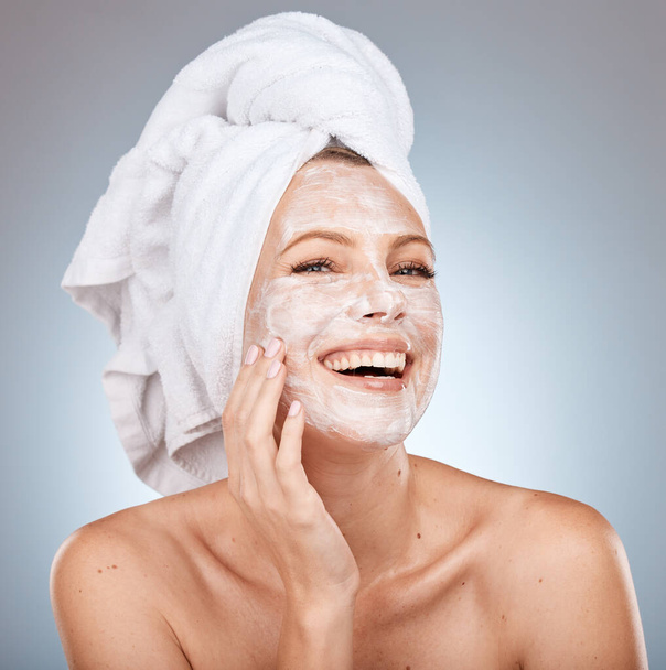 Skincare, facial cream and woman with mask on gray background studio for wellness, beauty and spa. Dermatology, cosmetics and happy girl with moisturizer, facial mask and skincare products for face. - Foto, Imagem