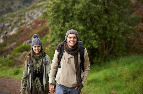 ハイキングは魂にとって良いことです。若いカップルが暖かく包まれ、一緒に山道をハイキング - 写真・画像