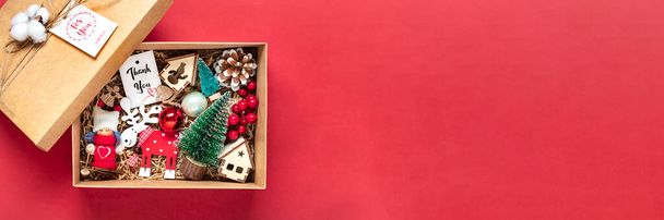Ručně vyrobený balíček péče, sezónní dárková krabice s hračkami, vánoční dekor na červeném stole Individuální ekologický koš pro rodinu, přátelé, dívka pro 24 Prosinec, Vánoce, Nový rok Byt ležel. - Fotografie, Obrázek