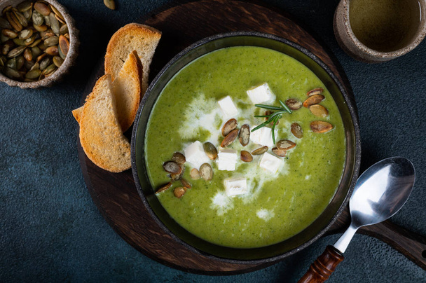 Broccoli cream soup in a bowl with toasted bread and cheese. - Fotó, kép