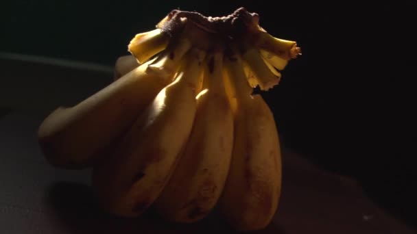 Στούντιο πλάνα από φρέσκες μπανάνες στο σκοτάδι - Πλάνα, βίντεο