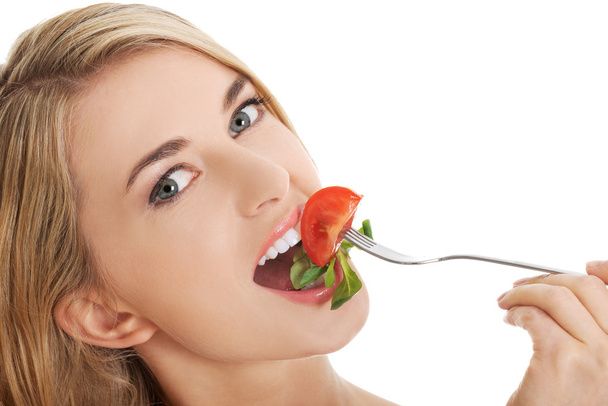 Smiling woman eating salat - Foto, imagen