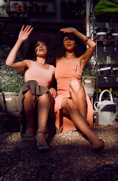 Hands, sunlight and shade with black woman friends blocking the sun while sitting together at a plant nursery. Spring, gardening and growth with a female and friend outdoor at a flower shop. - Foto, immagini
