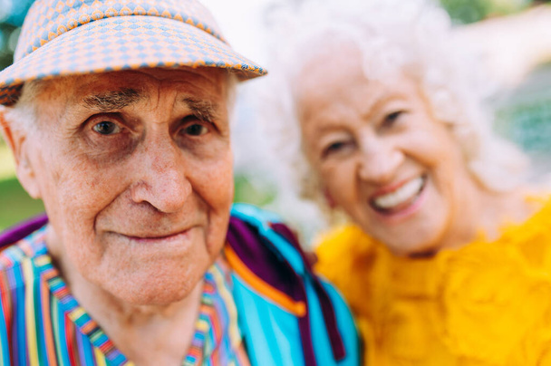 Old modern couple dressing fashionable colored clothes. Youthful grandmother and grandfather having fun outdoor and going wild. Representation of elderly people feeling young inside - Fotoğraf, Görsel