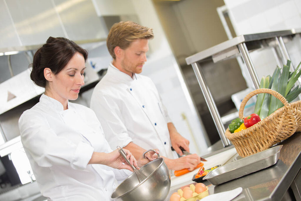 positive professional chef and cook working at restaurant kitchen - 写真・画像