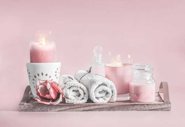 Pastel pink spa setting with candles,towels and cosmetic products. Beauty and skin care concept - Foto, Imagem