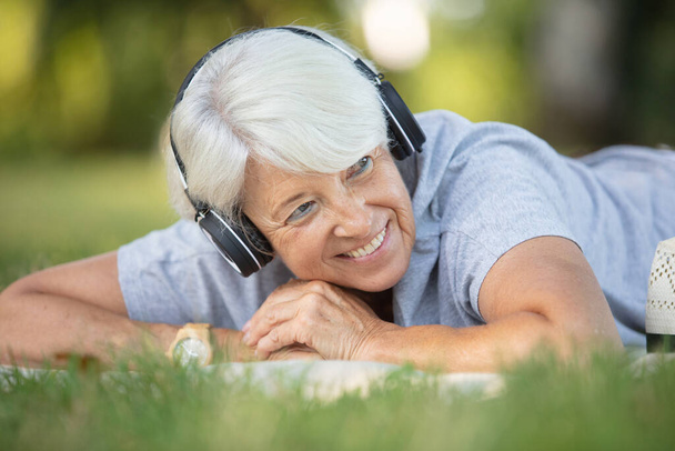 relaxed pensioner listening to music in nature - Fotoğraf, Görsel