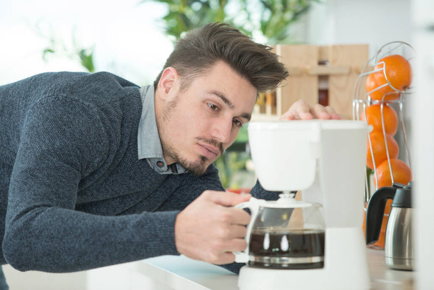 jong hipster mannetje maken filter koffie thuis - Foto, afbeelding
