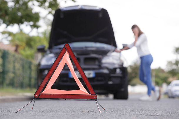 problemen auto en rode driehoek op de weg - Foto, afbeelding
