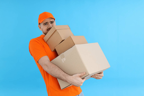 Concept de livraison, livreur avec boîtes sur fond bleu - Photo, image