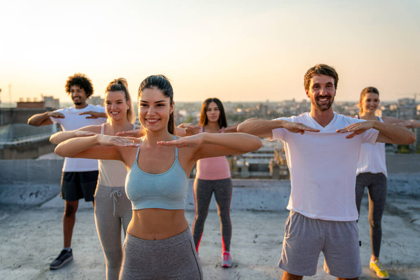 Group of happy fit people friends exercising together outdoor. Sport people healthy lifestyle concept. - Foto, Bild