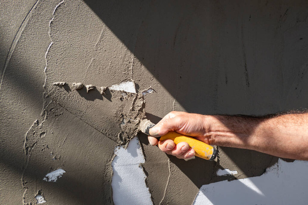 Worker putting cement on the wall to plaster it - Photo, Image