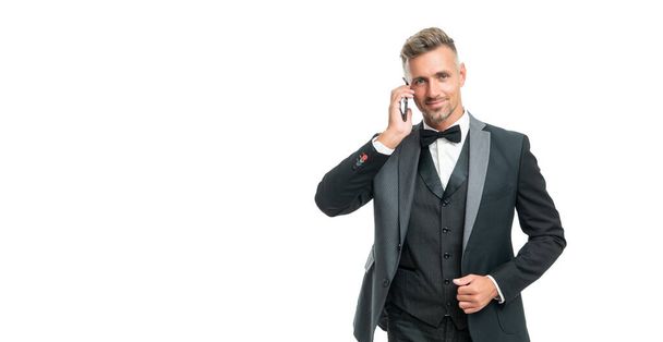 smiling businessman in tuxedo speak on phone isolated on white background with copy space. - Фото, зображення