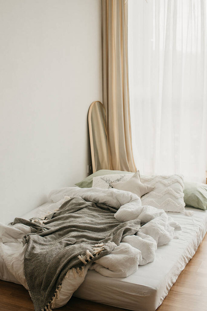 Una camera bianca con un letto e cuscini - Foto, immagini