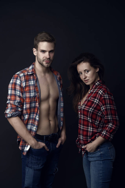 Family look. Fashion trend. Fashionable outfit. Woman and man wear checkered shirt. Sexy stylish couple black background. Young family couple. Summer fashion collection. Beautiful people concept. - Фото, изображение