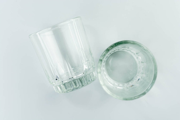 薄い灰色の背景に空のガラスカップ - 写真・画像