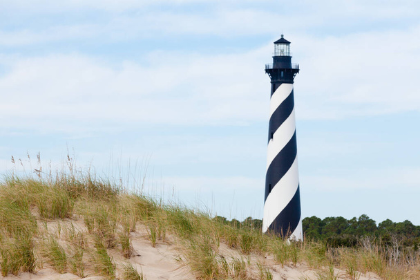 Cape Hatteras Lighthouse towers over beach dunes of Outer Banks island near Buxton, North Carolina, US - Photo, Image
