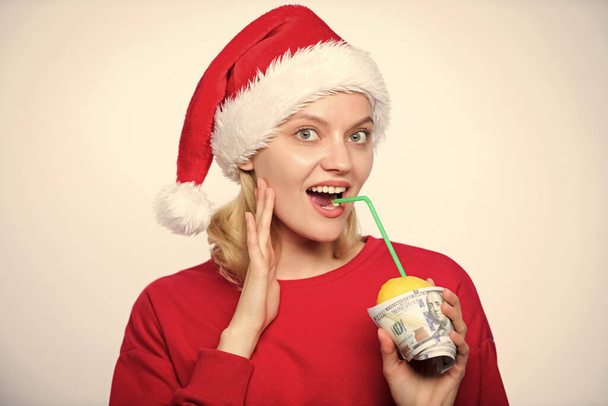 Totally natural lemon juice. Fresh lemonade drink with straw. Symbol of wealth and richness. Girl with lemon and money. Lemon money concept. Girl santa hat drink juice lemon wrapped in banknote. - Photo, image