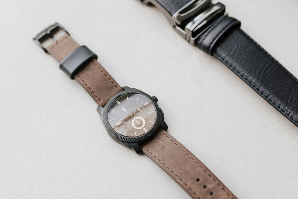 Presentazione di dettaglio orologio a mano casual marrone e cintura formale nera con spazio vuoto per il materiale di marketing. - Foto, immagini