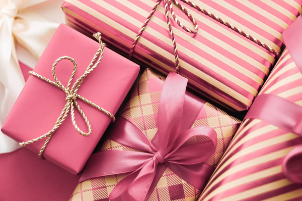 Regalos navideños y regalos de lujo envueltos, cajas de regalo rosas como regalo sorpresa para cumpleaños, Navidad, Año Nuevo, Día de San Valentín, día de boxeo, compras de bodas y días festivos o entrega de cajas de belleza - Foto, imagen