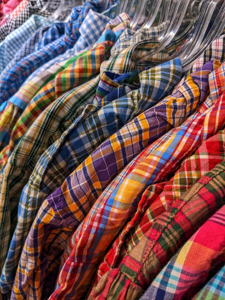 Muitas camisas quadriculadas penduradas em cabides em uma loja - Foto, Imagem