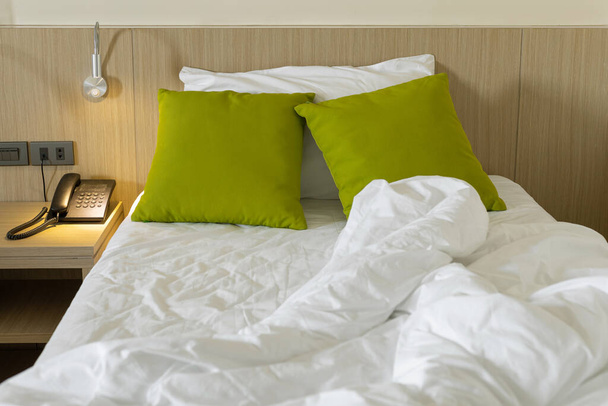 Lençóis bagunçados e travesseiro na parte da manhã no quarto - Foto, Imagem
