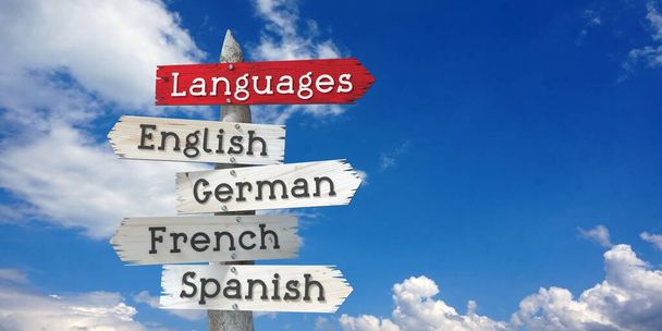 Concetto linguistico - Inglese, tedesco, francese, spagnolo - cartello in legno con cinque frecce - Foto, immagini