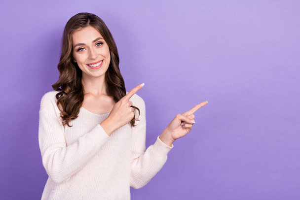 Photo of young cute adorable pretty nice lady wear white pullover directing fingers empty space information ad isolated on violet color background. - Φωτογραφία, εικόνα