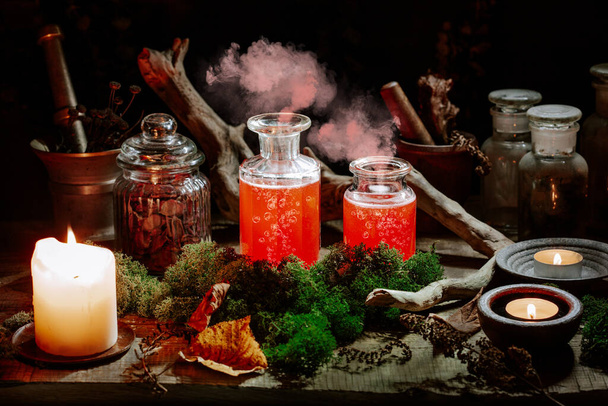 Hexerei-Stilllebenskonzept mit Räuchertrank, Kräuterzutaten Kerzen und magischen Geräten - Foto, Bild