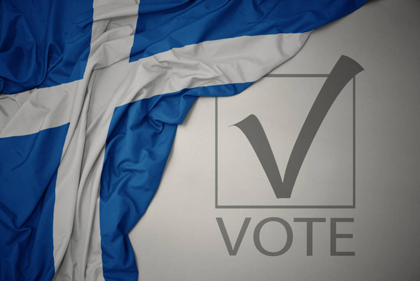 ondeando colorida bandera nacional de Escocia sobre un fondo gris con voto de texto. concepto de elección. Ilustración 3D - Foto, imagen