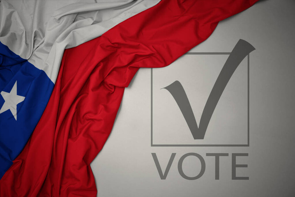 ondeando colorida bandera nacional de chile sobre un fondo gris con voto de texto. concepto de elección. Ilustración 3D - Foto, imagen