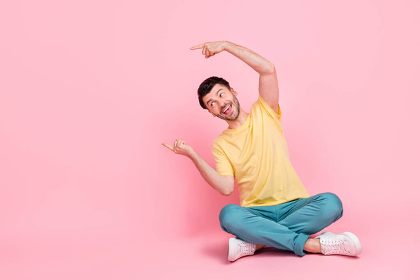 Photo of positive glad man two arm direct empty space offer cool proposition buy trendy quality clothes isolated on pink color background. - Foto, imagen