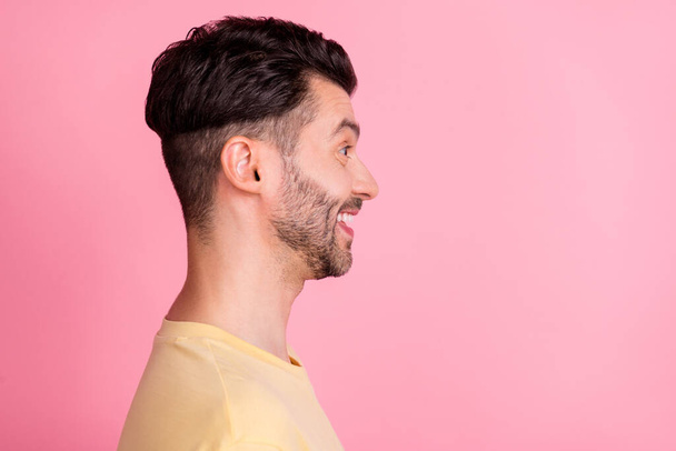 Side profile photo of optimistic satisfied man stylish haircut yellow t-shirt look empty space smiling isolated on pink color background. - Fotó, kép