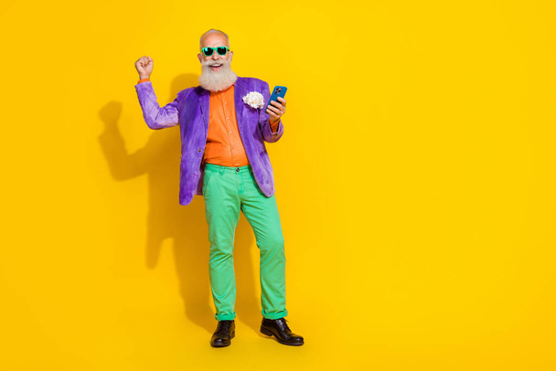Full size photo of retired pensioner grandfather use gadget online shopping win sales isolated on bright color background. - Фото, зображення
