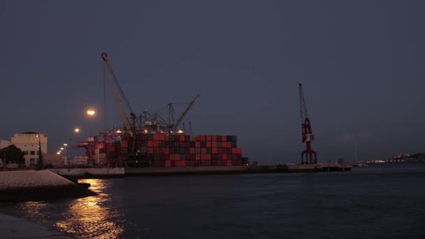 Un buque de carga se encuentra en el puerto temprano en la noche. Mid shot - Imágenes, Vídeo